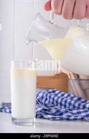 Non-Homogenized, whole milk, cream-top layered dairy product, Creamline Milk concept. Organic farm natural, unpasteurized milk in glass and jug, on wh Stock Photo