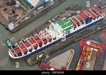 Tug boats guiding a container ship into Seaforth Docks, Liverpool, Merseyside, north west England,UK Stock Photo