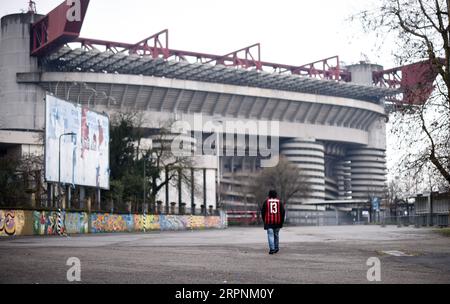 200302 -- MILAN, March 2, 2020 Xinhua -- A fan of AC Milan walks outside the San Siro stadium after a Serie A soccer match between AC Milan and Genoa was postponed due to the recent coronavirus outbreak in Milan, Italy, March 1, 2020. The number of Italians infected by the coronavirus continues to accelerate, Giovanni Rezza, head of the Italian High Institute of Health s Department of Infectious Diseases, said Sunday, adding that the country was at least a week away from seeing a peak in the outbreak. According to Angelo Borrelli, Civil Protection Department chief and Extraordinary Commissione Stock Photo