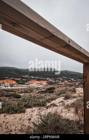 View from boardwalk into the sand dune, mountain and beach residential area in Quiaios, Portugal on a foggy day. Low angle point of view Stock Photo