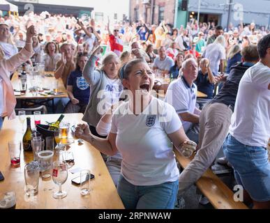 Fans cheer England while watching the Women's World Cup final against Spain at a bar in Nottingham. Stock Photo