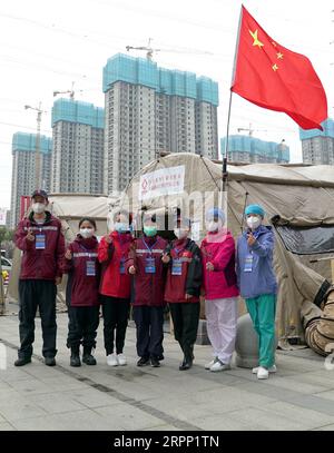 200308 -- WUHAN, March 8, 2020 -- Medical workers of the Wuhan Livingroom makeshift hospital pose for a group photo in Wuhan, central China s Hubei Province, March 8, 2020. The Wuhan Livingroom makeshift hospital officially closed on Sunday.  CHINA-HUBEI-WUHAN-MAKESHIFT HOSPITAL-CLOSE CN RaoxLiwen PUBLICATIONxNOTxINxCHN Stock Photo