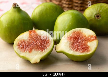 Heap of fresh whole and halved green figs close up as dessert Stock Photo