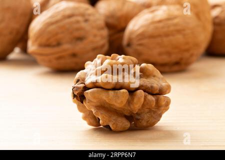 Single peeled walnut close up and walnuts with shell on the background Stock Photo