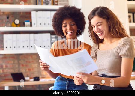 Two Female Business Colleagues With Documents Meeting Together In Office Stock Photo