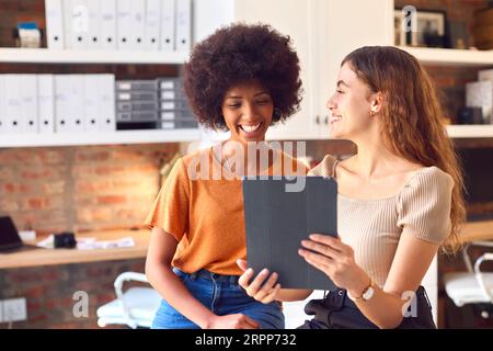 Two Female Business Colleagues With Digital Tablet Meeting Together In Office Stock Photo
