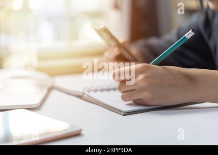 woman hand with pencil writing on notebook. Stock Photo