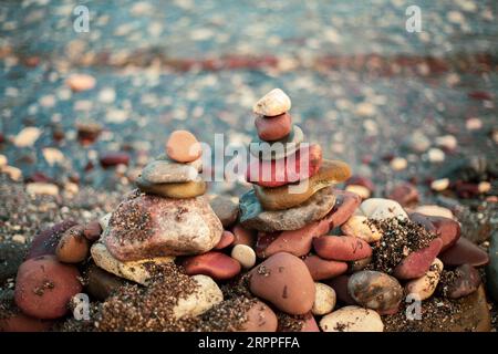 Stack of round smooth stones by the sea Stock Photo