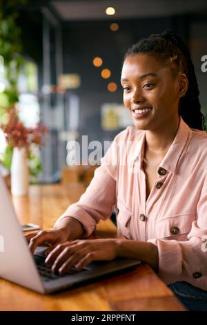 Young Businesswoman With Coffee Working On Laptop Sitting In Cafe Or Office Stock Photo
