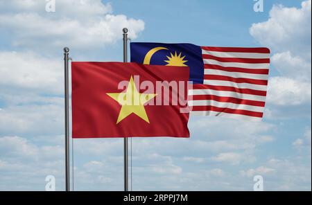 Malaysia and Vietnam flag waving together in the wind on blue sky, two country cooperation concept Stock Photo