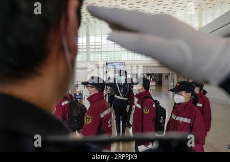 200318 -- WUHAN, March 18, 2020 -- Security personnel salute to medical staff from Fujian Province at Wuhan Tianhe International Airport in Wuhan, central China s Hubei Province, March 18, 2020. A total of 2,520 medical assistance staffers left Hubei by 22 chartered flights from the airport on Wednesday as the epidemic outbreak in the hard-hit province has been subdued.  CHINA-WUHAN-MEDICS-DEPARTURE CN FeixMaohua PUBLICATIONxNOTxINxCHN Stock Photo