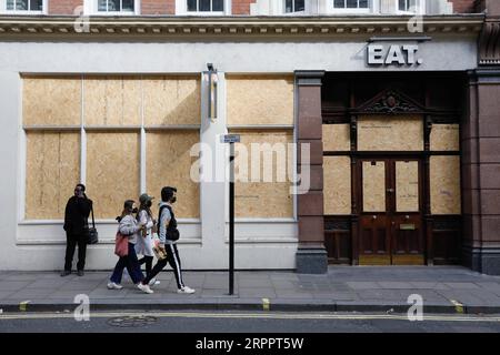 200321 -- LONDON, March 21, 2020 Xinhua -- People walk past a closed restaurant in central London, Britain, on March 21, 2020. As of 9a.m. 0900GMT on Saturday, 72,818 people have been tested in Britain, of which 67,800 were confirmed negative and 5,018 were confirmed positive. 233 patients in the country who tested positive for the virus have died. Photo by Tim Ireland/Xinhua BRITAIN-LONDON-COVID-19 PUBLICATIONxNOTxINxCHN Stock Photo