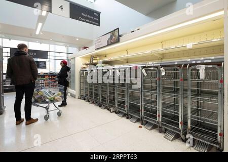 200321 -- LONDON, March 21, 2020 Xinhua -- People stand by almost-empty shelves of a supermarket in London, Britain, March 21, 2020. As of 9a.m. 0900GMT on Saturday, 72,818 people have been tested in Britain, of which 67,800 were confirmed negative and 5,018 were confirmed positive. 233 patients in the country who tested positive for the virus have died. Xinhua BRITAIN-LONDON-COVID-19 PUBLICATIONxNOTxINxCHN Stock Photo