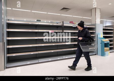 200321 -- LONDON, March 21, 2020 Xinhua -- A man walks by empty shelves of a supermarket in London, Britain, March 21, 2020. As of 9a.m. 0900GMT on Saturday, 72,818 people have been tested in Britain, of which 67,800 were confirmed negative and 5,018 were confirmed positive. 233 patients in the country who tested positive for the virus have died. Xinhua BRITAIN-LONDON-COVID-19 PUBLICATIONxNOTxINxCHN Stock Photo
