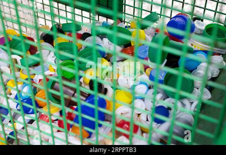 Urban Recycling bin full of plastic bottle caps. Environment and global friendly concept Stock Photo