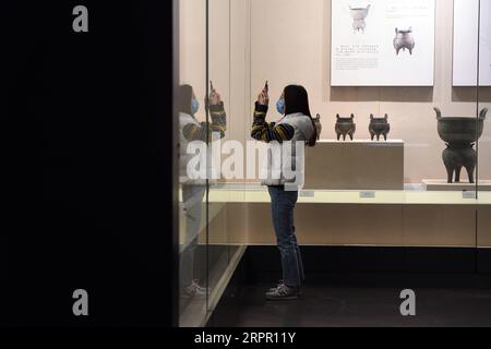 200324 -- HEFEI, March 24, 2020 -- A visitor takes photos of exhibits at the Anhui Museum in Hefei, east China s Anhui Province, March 24, 2020. Under strict measures taken to fight against the COVID-19, the Anhui Museum reopened in an orderly manner on Tuesday to visitors who have made real-name reservations and control the number of visitors below 2,000 a day. Before entering into the museum, each visitor has to scan QR code for health check and receive temperature checking. Photo by /Xinhua CHINA-ANHUI-HEFEI-ANHUI MUSEUM-REOPEN CN ZhouxMu PUBLICATIONxNOTxINxCHN Stock Photo