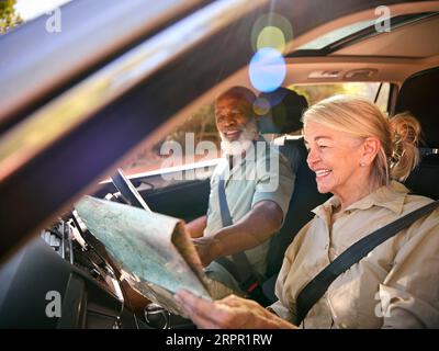 Senior Couple On Day Trip Out Driving In Car Reading Map Stock Photo