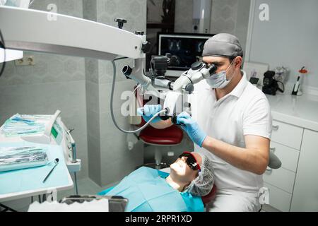 Dentist makes an operation using a dental microscope. Stock Photo