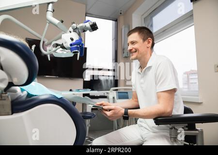 Dentist communicates with patient in dental office. Stock Photo