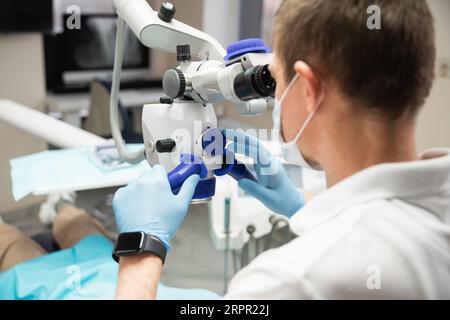 Dentist makes an operation using a dental microscope. Stock Photo