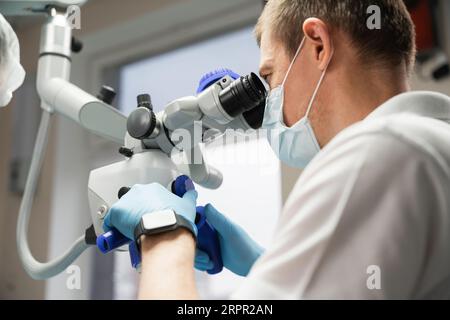 Dentist makes an operation using a dental microscope. Stock Photo