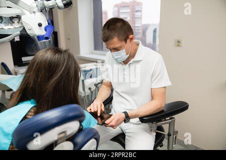 Dentist communicates with patient in dental office. Stock Photo