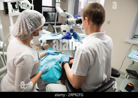 Dentist makes an operation using a dental microscope. Stock Photo
