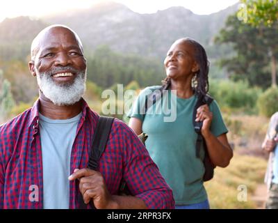 Senior Couple Enjoying Hiking Through Countryside Together Stock Photo