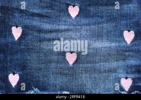 jean fabric with light pink embroidery hearts pattern Stock Photo
