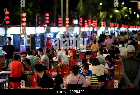 200326 -- HAIKOU, March 26, 2020 -- People eat snacks at a night market in Haikou, capital of south China s Hainan Province, March 26, 2020. South China s island province of Hainan on Tuesday reduced its existing number of cases of novel coronavirus disease COVID-19 to zero. People s life here is gradually returning to normal.  CHINA-HAINAN-HAIKOU-LIFE-BACK TO NORMAL CN GuoxCheng PUBLICATIONxNOTxINxCHN Stock Photo