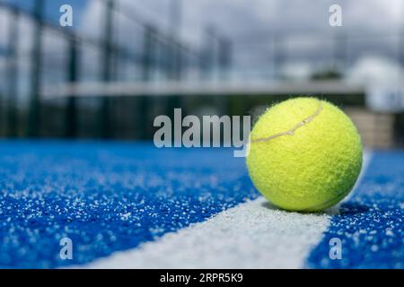 selective focus, a ball over the line of a blue paddle tennis court Stock Photo