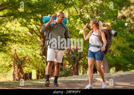 Couple With Backpacks Giving Each Other High Five On Vacation Hiking ...