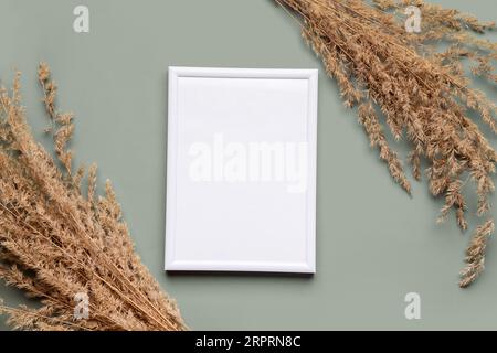 Blank picture frame with pampas grass on green background Stock Photo