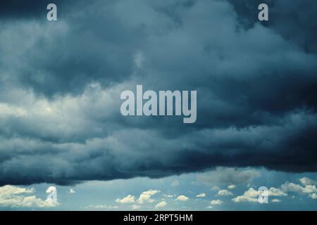 Dark storm clouds with breaking sunlight Stock Photo