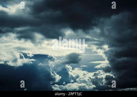Dark storm clouds with breaking sunlight Stock Photo