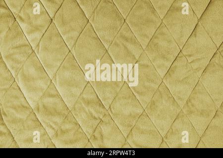 Quilted velours fabric background. Yellow texture blanket or puffer jacket, stiched with diamond pattern, soft wrinkled surface, crupmed textile Stock Photo
