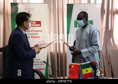 200423 -- DAKAR, April 23, 2020 Xinhua -- Chinese Ambassador to Senegal Zhang Xun L and Senegalese Minister of Health and Social Action Abdoulaye Diouf Sarr exchange reception documents in Dakar, Senegal, on April 22, 2020. The second batch of medical aids offered by Chinese government to Senegal was received Wednesday by Senegalese Minister of Health and Social Action Abdoulaye Diouf Sarr in Dakar. Photo by Eddy Peters/Xinhua SENEGAL-MEDICAL AIDS-CHINA PUBLICATIONxNOTxINxCHN Stock Photo
