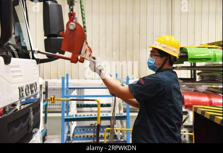 200428 -- JINAN, April 28, 2020 -- An employee works at an assembly line of China National Heavy Duty Truck Group Co., Ltd. in Jinan, capital of east China s Shandong Province, April 28, 2020. The leading heavy-duty truck maker of China has made timely adjustment of the supply chain after the outbreak of COVID-19, which enabled it to seize the opportunity of market recovery. At present, it has received orders of more than 40,000 trucks.  CHINA-SHANDONG-HEAVY-DUTY TRUCKS-PRODUCTION-RESUMPTIONCN WangxKai PUBLICATIONxNOTxINxCHN Stock Photo