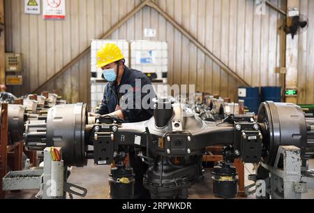 200428 -- JINAN, April 28, 2020 -- An employee works at an assembly line of China National Heavy Duty Truck Group Co., Ltd. in Jinan, capital of east China s Shandong Province, April 28, 2020. The leading heavy-duty truck maker of China has made timely adjustment of the supply chain after the outbreak of COVID-19, which enabled it to seize the opportunity of market recovery. At present, it has received orders of more than 40,000 trucks.  CHINA-SHANDONG-HEAVY-DUTY TRUCKS-PRODUCTION-RESUMPTIONCN WangxKai PUBLICATIONxNOTxINxCHN Stock Photo