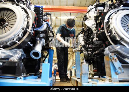 200428 -- JINAN, April 28, 2020 -- An employee works at an assembly line of China National Heavy Duty Truck Group Co., Ltd. in Jinan, capital of east China s Shandong Province, April 28, 2020. The leading heavy-duty truck maker of China has made timely adjustment of the supply chain after the outbreak of COVID-19, which enabled it to seize the opportunity of market recovery. At present, it has received orders of more than 40,000 trucks.  CHINA-SHANDONG-HEAVY-DUTY TRUCKS-PRODUCTION-RESUMPTIONCN WangxKai PUBLICATIONxNOTxINxCHN Stock Photo