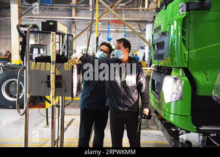 200428 -- JINAN, April 28, 2020 -- Employees work at an assembly line of China National Heavy Duty Truck Group Co., Ltd. in Jinan, capital of east China s Shandong Province, April 28, 2020. The leading heavy-duty truck maker of China has made timely adjustment of the supply chain after the outbreak of COVID-19, which enabled it to seize the opportunity of market recovery. At present, it has received orders of more than 40,000 trucks.  CHINA-SHANDONG-HEAVY-DUTY TRUCKS-PRODUCTION-RESUMPTIONCN WangxKai PUBLICATIONxNOTxINxCHN Stock Photo