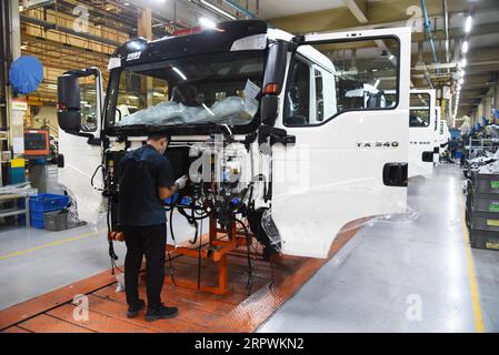 200428 -- JINAN, April 28, 2020 -- An employee works at an assembly line of China National Heavy Duty Truck Group Co., Ltd. in Jinan, capital of east China s Shandong Province, April 28, 2020. The leading heavy-duty truck maker of China has made timely adjustment of the supply chain after the outbreak of COVID-19, which enabled it to seize the opportunity of market recovery. At present, it has received orders of more than 40,000 trucks.  CHINA-SHANDONG-HEAVY-DUTY TRUCKS-PRODUCTION-RESUMPTIONCN WangxKai PUBLICATIONxNOTxINxCHN Stock Photo