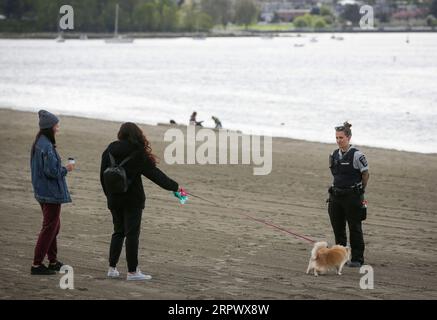200501 -- VANCOUVER, May 1, 2020 Xinhua -- An officer talks to people while observing social distancing at English Bay in Vancouver, Canada, April 30, 2020. Photo by Liang Sen/Xinhua CANADA-VANCOUVER-COVID-19-SOCIAL DISTANCING PUBLICATIONxNOTxINxCHN Stock Photo