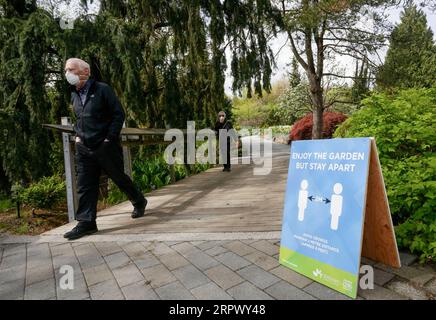 200501 -- VANCOUVER, May 1, 2020 Xinhua -- A man with a face mask walks past a sign to remind visitors to stay apart at the reopened VanDusen Botanical Garden in Vancouver, Canada, on May 1, 2020. Vancouver started on Friday to gradually reopen public recreation facilities with safety measures amid COVID-9 pandemic. Photo by Liang Sen/Xinhua CANADA-VANCOUVER-COVID-19-RECREATION FACILITIES-REOPENING PUBLICATIONxNOTxINxCHN Stock Photo