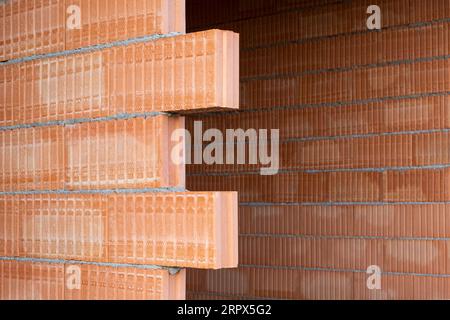 Red clay Ceramic Thermo Bricks construction material. Construction site with walls. Stock Photo