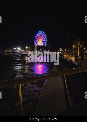 Cairns, Australia - November 17, 2022: The Reef Eye Ferris Wheel viewed from Cairns Esplanade at night in summer. Stock Photo