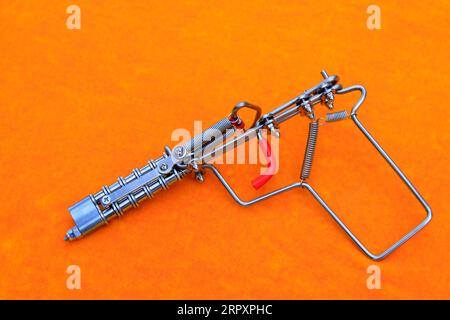 toy guns made by iron wire in orange background Stock Photo