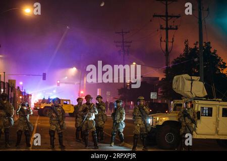 200531 -- MINNEAPOLIS, May 31, 2020 Xinhua -- Members of the Minnesota National Guard block the road while firefighters extinguish a fire set in a Wells Fargo bank by protesters earlier in the night in Minneapolis, the United States, on May 30, 2020. Thousands of protesters took to the streets of Minneapolis Friday night, defying a citywide 8 p.m. curfew that had been announced earlier that day. Businesses were burned and vandalized, as the rioting continued, said local media reports. Photo by Angus Alexander/Xinhua U.S.-MINNEAPOLIS-PROTEST-AFTERMATH PUBLICATIONxNOTxINxCHN Stock Photo