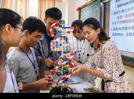 200601 -- NANNING, June 1, 2020 -- A teacher and students study a DNA structure model at a middle school in Xingye County, south China s Guangxi Zhuang Autonomous Region, May 29, 2020. Guangxi, one of the major battlefields in China s poverty alleviation campaign, has been making painstaking efforts to improve education for poverty-stricken children, as schooling is believed to be the best way to empower the youngsters to lift their families out of poverty. The region has taken various measures in this regard, including granting students stipends, improving school facilities and nutritional co Stock Photo