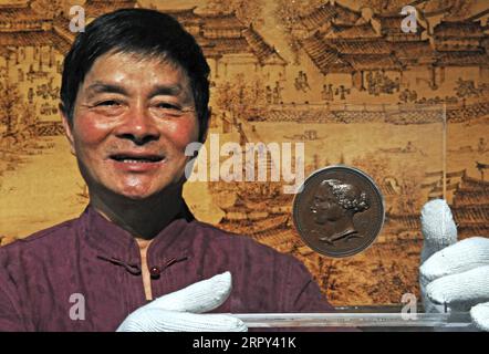 200613 -- HUZHOU, June 13, 2020 -- Wang Yishi shows the gold prize won by Jili silk during the World Expo in 1851 at his Jili silk museum in Huzhou City, east China s Zhejiang Province, June 11, 2020. Jili silk, produced in Jili Village of Huzhou, is famous for its high quality. It was designated as the material to make ropes for Chinese emperors since the middle of the Ming Dynasty 1368-1644. In 2011, the making technique of the silk was listed as one of the national intangible cultural heritages. It is known worldwide since 1851 when Jili silk won the first gold prize for China during the Wo Stock Photo